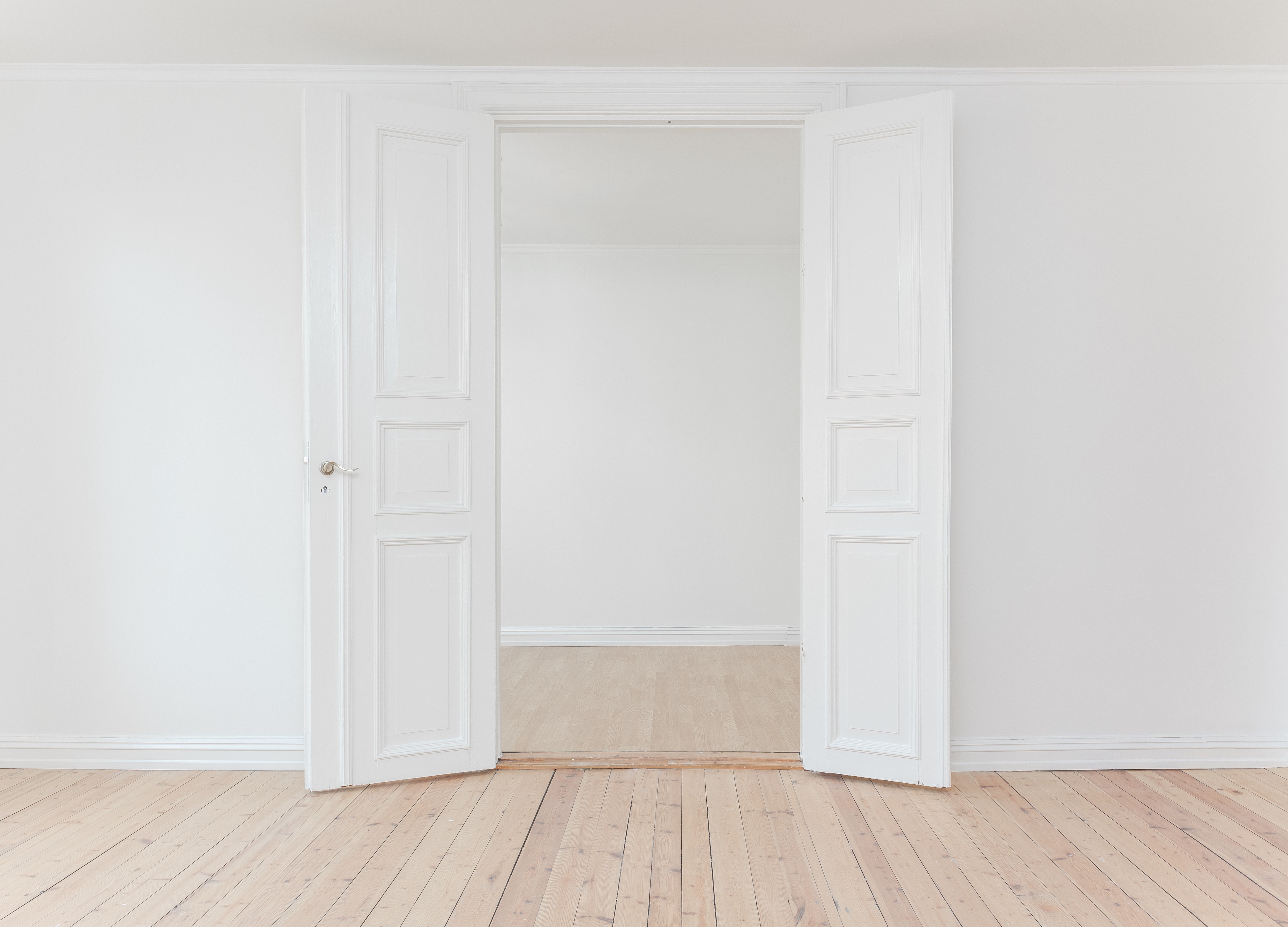 White doors open to an empty room much like the empty room of the author's daughter