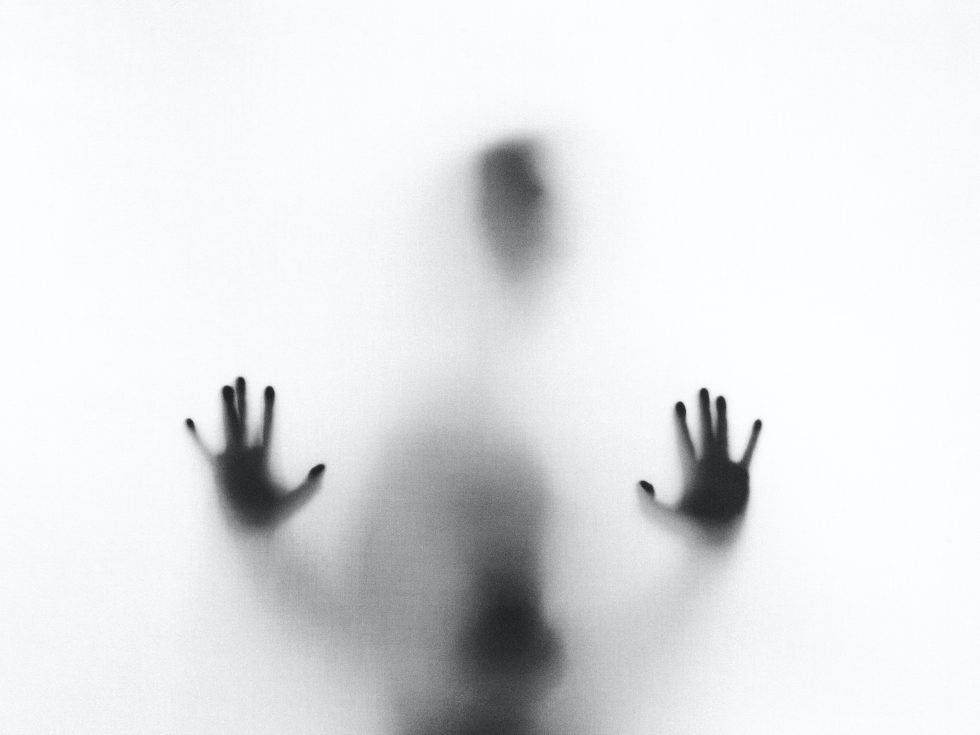 Figure of person reaching out in the fog of burnout or crisis