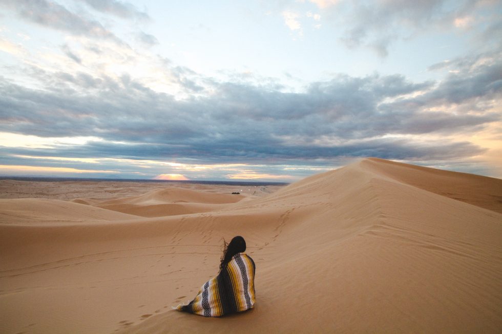 Woman waits in the desert for rain during monsoon season